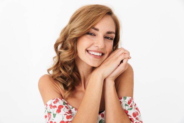 Photo d'une jeune femme joyeuse et heureuse posant isolée sur un mur blanc.