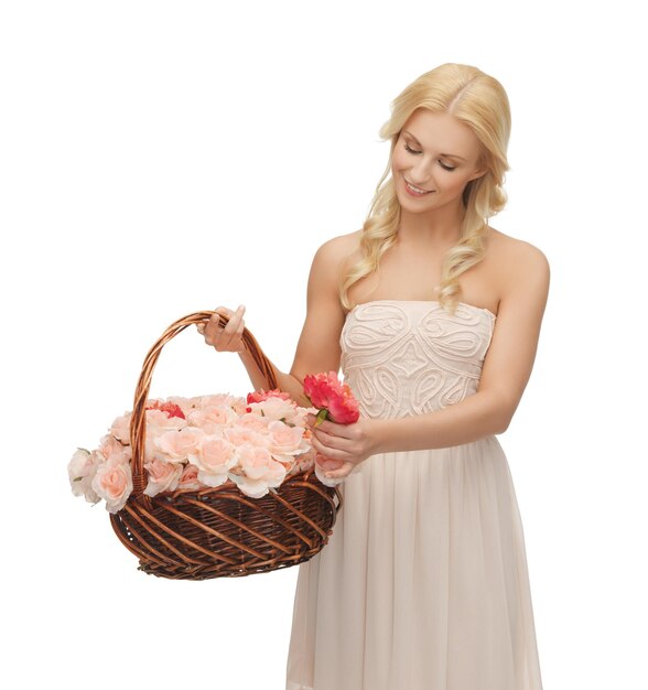 photo de jeune femme avec un panier plein de fleurs.