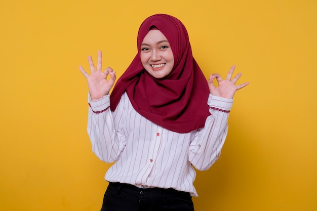 Photo de jeune femme portant le hijab disant bon geste, regarde joyeusement l'expression