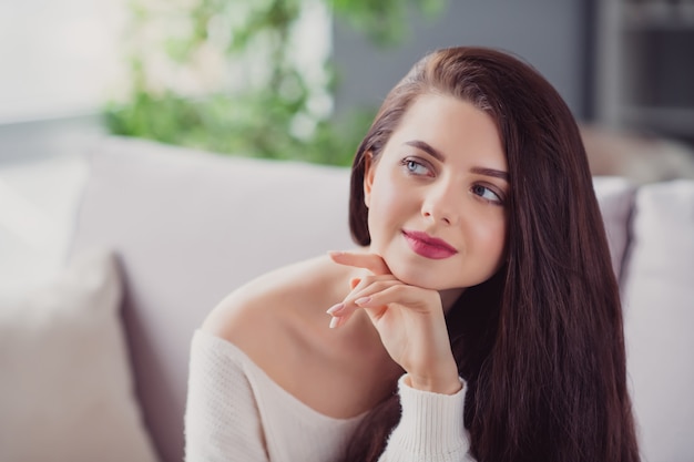 Photo de jeune femme séduisante heureux sourire positif main toucher menton rêve curieux confort à la maison week-end