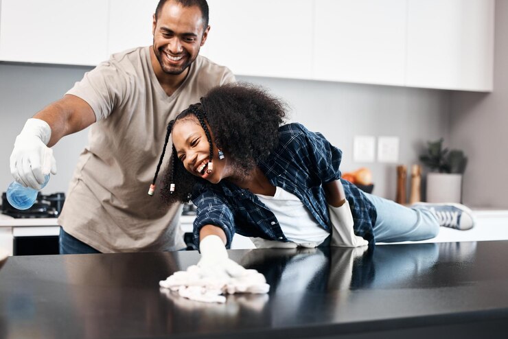 Photo photo d'une jeune fille aidant son père à nettoyer le comptoir de la cuisine à la maison