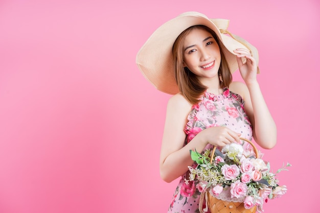 Photo de jeune fille asiatique portant une robe à fleurs sur fond rose