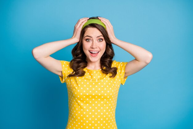 Photo d'une jeune fille folle étonnée toucher les mains tête crier fort isolé sur fond de couleur bleu