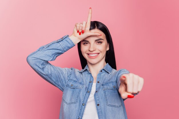 Photo d'une jeune fille joyeuse fait du doigt pointé du geste du perdant vous moquez de l'intimidation sur fond violet isolé