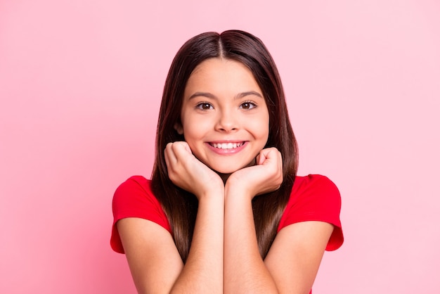 Photo d'une jeune fille latine positive à l'appareil photo toucher le menton par les poings à pleines dents souriant isolé sur fond de couleur rose