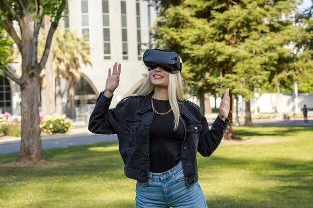 Photo d'une jeune fille portant des lunettes VR et levant les mains