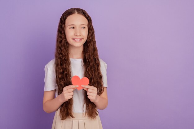 Photo de jeune fille tenir coeur papier valentine look espace vide isolé sur fond violet