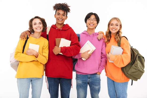 Photo d'un jeune groupe émotionnel d'étudiants amis debout isolé, posant.