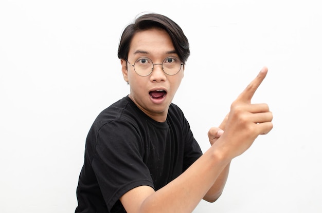 photo de jeune homme asiatique choqué joyeusement pointant vers le haut pour copier l'espace pour le modèle d'annonces