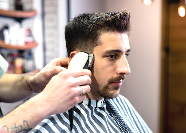 photo d'un jeune homme au barbier qui coupe les cheveux