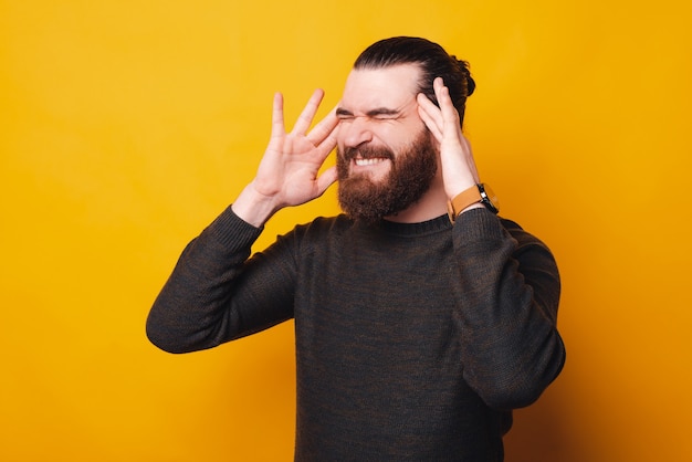 Une photo d'un jeune homme barbu ayant mal à la tête