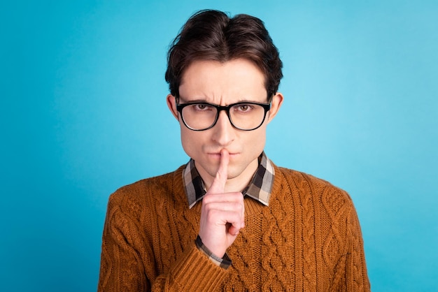 Photo de jeune homme couvrir les doigts de la bouche chut confidentiel garder secret isolé sur fond bleu