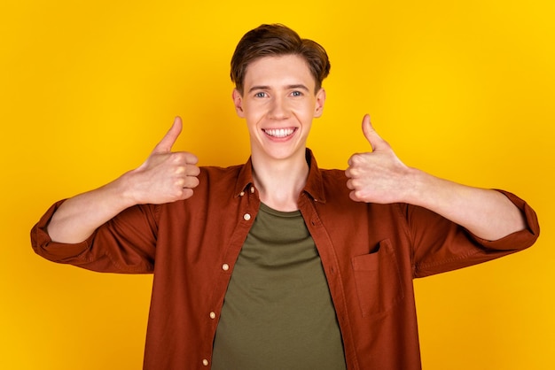 Photo d'un jeune homme promoteur show thumbsup super parfait suggérer annonce isolé sur fond de couleur jaune