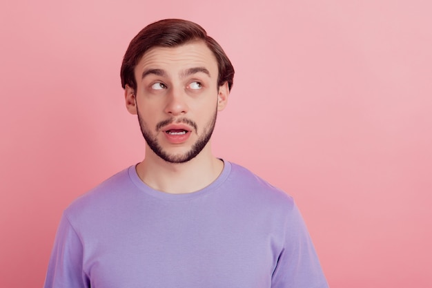 Photo d'un jeune homme rêveur regarde l'espace vide doute imaginez plan isolé sur fond de couleur pastel