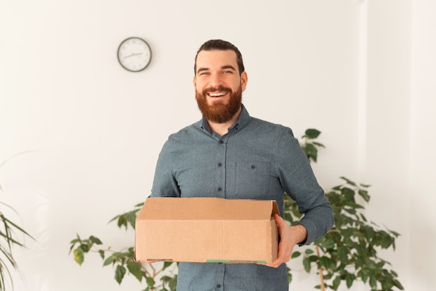 Photo d'un jeune homme souriant se déplaçant vers un autre bureau ou emploi