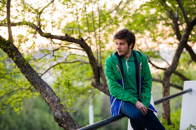 Photo d'un jeune homme utilisant un smartphone au coucher du soleil