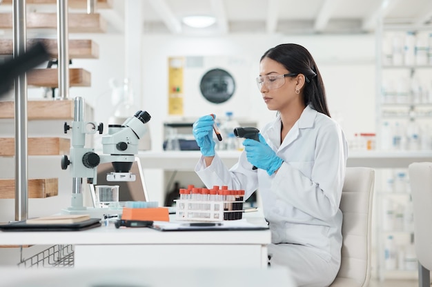 Photo d'un jeune scientifique utilisant un lecteur de code-barres tout en travaillant avec des échantillons dans un laboratoire