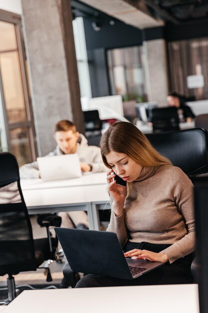 Photo de jeunes travaillant devant un ordinateur dans un bureau de coworking moderne