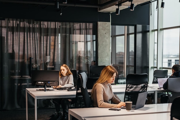 Photo de jeunes travaillant devant un ordinateur dans un bureau de coworking moderne