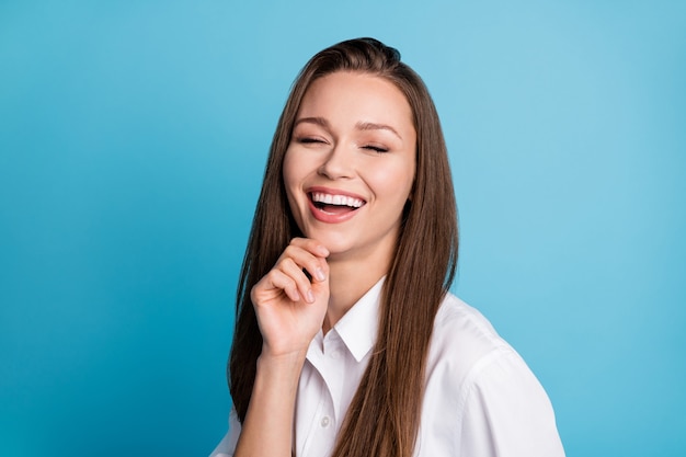 Photo de jolie dame bonne humeur amicale de rire à haute voix porter une chemise blanche isolée sur fond de couleur bleu