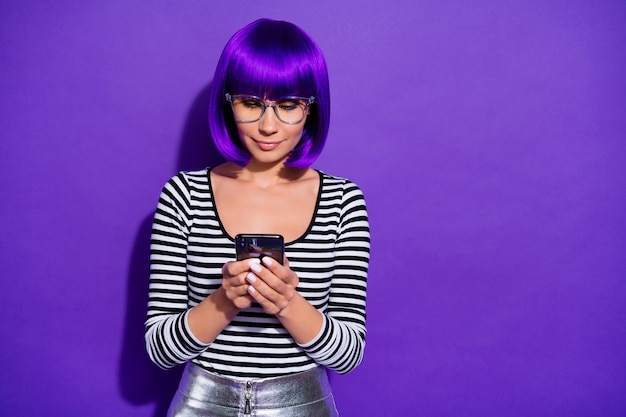 Photo de jolie dame tenant par la main nouveau téléphone écrit e-mail amis portent des caractéristiques pull rayé fond violet isolé