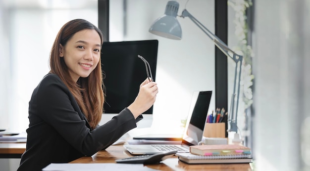 Photo d'une jolie femme d'affaires assise à son bureau dans un bureau