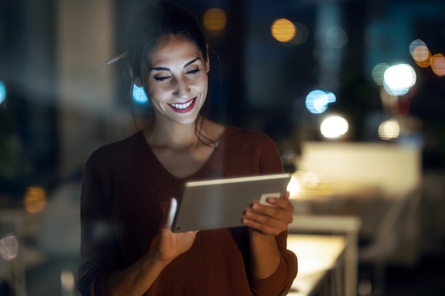 Photo d'une jolie femme d'affaires intelligente prenant une pause en train de cheaker sa tablette numérique au bureau.