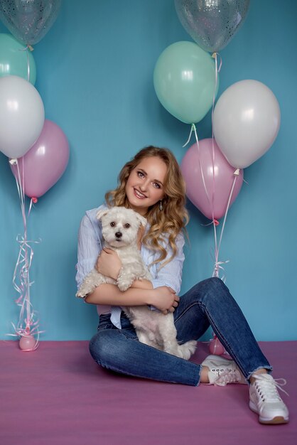 Photo de jolie femme avec chien et de nombreux ballons colorés