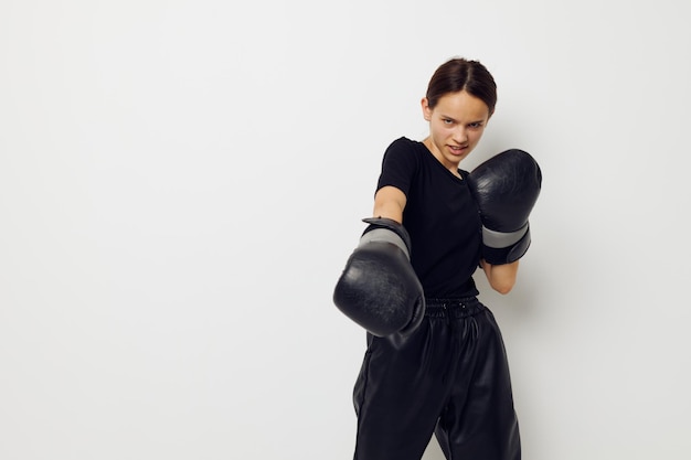 Photo jolie fille en gants de boxe en pantalon noir et un entraînement de fitness Tshirt