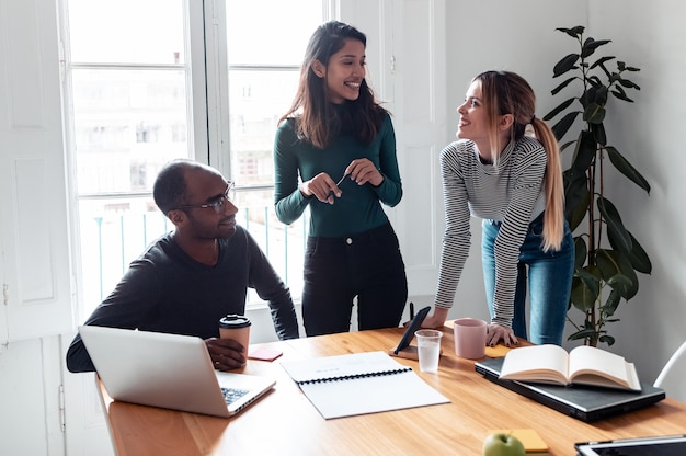 Photo d'une jolie jeune femme entrepreneure expliquant un projet à ses collègues sur un lieu de coworking.