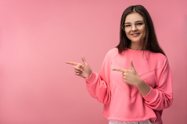 Photo de jolie jeune femme à lunettes pointe sur le côté gauche