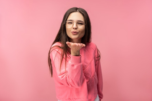 Photo de jolie jeune femme à lunettes souffle un baiser