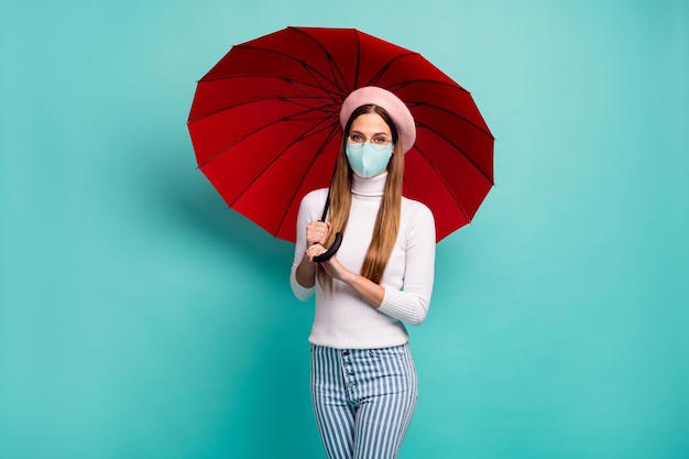 Photo d'une jolie voyageuse tenir un parapluie porter un masque médical spécifications béret col roulé jeans isolé fond de couleur sarcelle