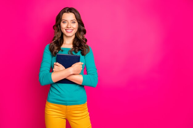 Photo de joyeuse belle jeune jolie positive souriante rayonnante à pleines dents câlins son livre à son fond de couleur vibrante fuchsia isolé