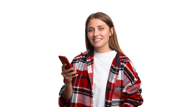 Photo de joyeuse jeune femme tenant un smartphone et regardant la caméra confiante sur fond blanc