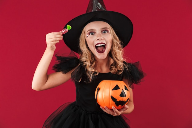 Photo de joyeuse petite fille sorcière en costume d'halloween de carnaval