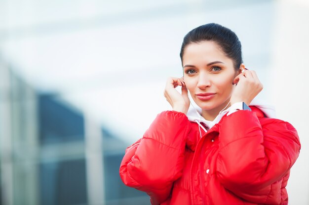 Photo de Joyful Fitness Woman 30s dans Sportswear Toucher une oreille Bluetooth