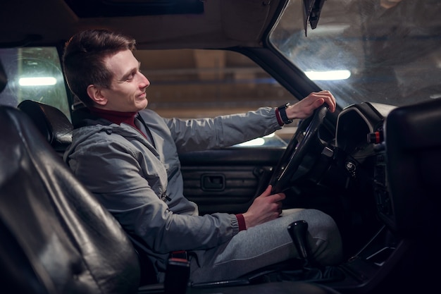 Photo latérale d'un homme assis dans une voiture