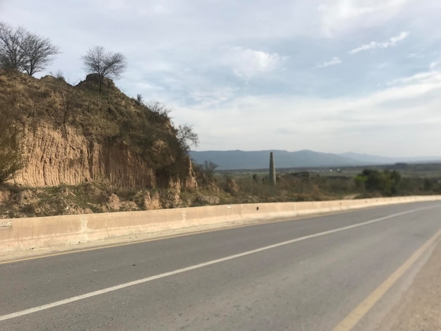 photo longue d'une route vide avec un fond de montagne