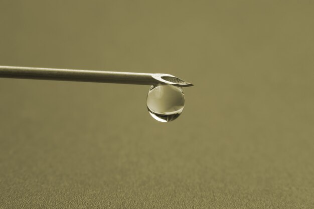 Photo macro d'une aiguille médicale pour injection avec une goutte de liquide