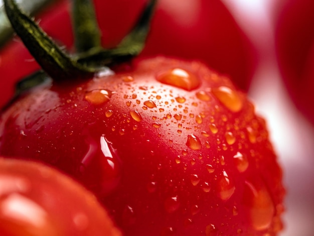 Photo macro de tomate cerise rouge fraîche avec des gouttes d'eau