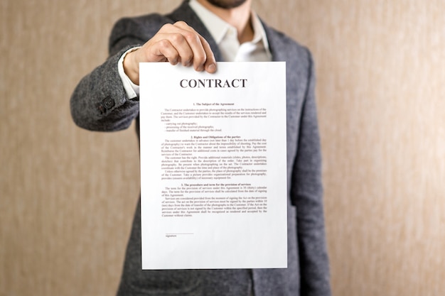 Photo de mains d'homme tenant un contrat avec un texte aléatoire. Concept d'entreprise.