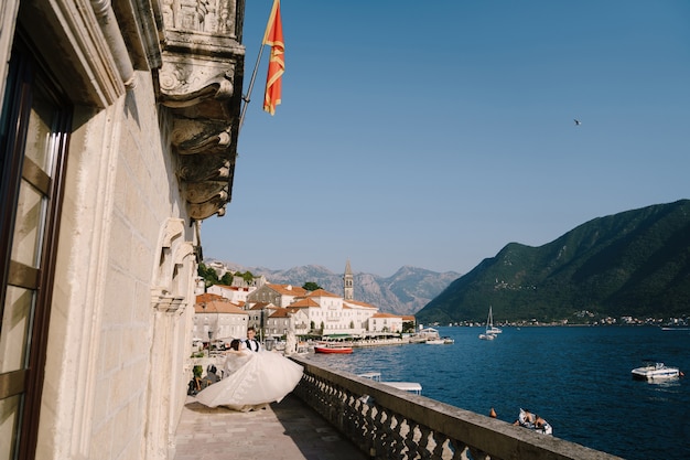 Photo de mariage Fineart au Monténégro perast un couple de mariage sur la terrasse de l'hôtel avec vue panoramique