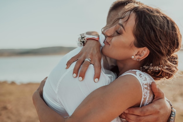 Photo de mariage. Un jeune couple marié s'amusant et dansant au bord d'un grand lac. Mise au point sélective. Photo de haute qualité