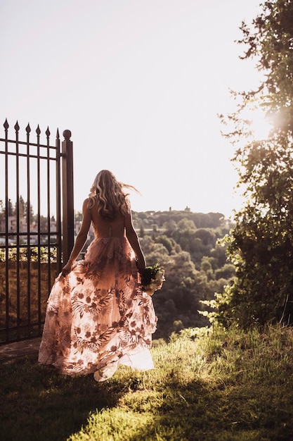 photo de la mariée de dos à l'aube belle robe de mariée légère