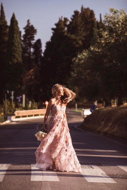 photo de la mariée sur la route à l'aube belle robe de mariée légère