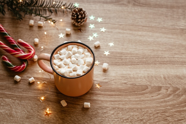 Photo de mauvaise humeur de Noël avec une tasse de café rose avec des guimauves et des confettis