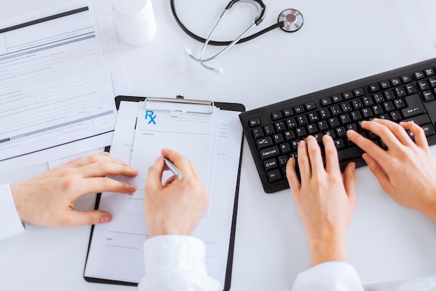 photo d'un médecin et d'une infirmière écrivant un papier d'ordonnance