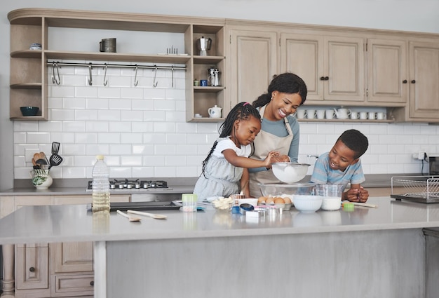 Photo d'une mère cuisinant avec ses enfants à la maison