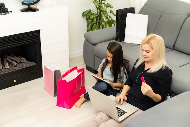 photo d'une mère et d'un enfant heureux avec un ordinateur portable, faisant des achats en ligne